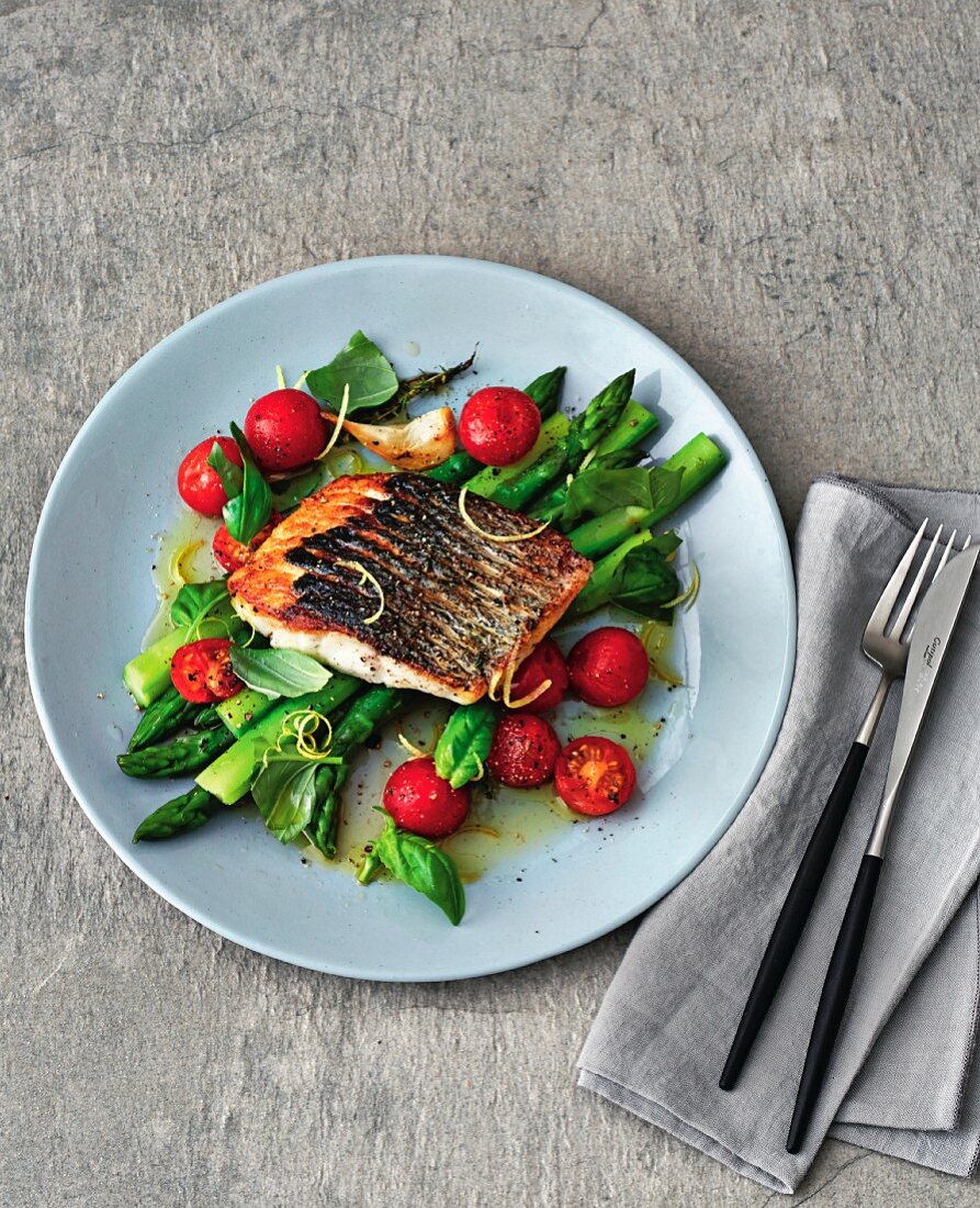 Wild sea bass with asparagus and tomatoes