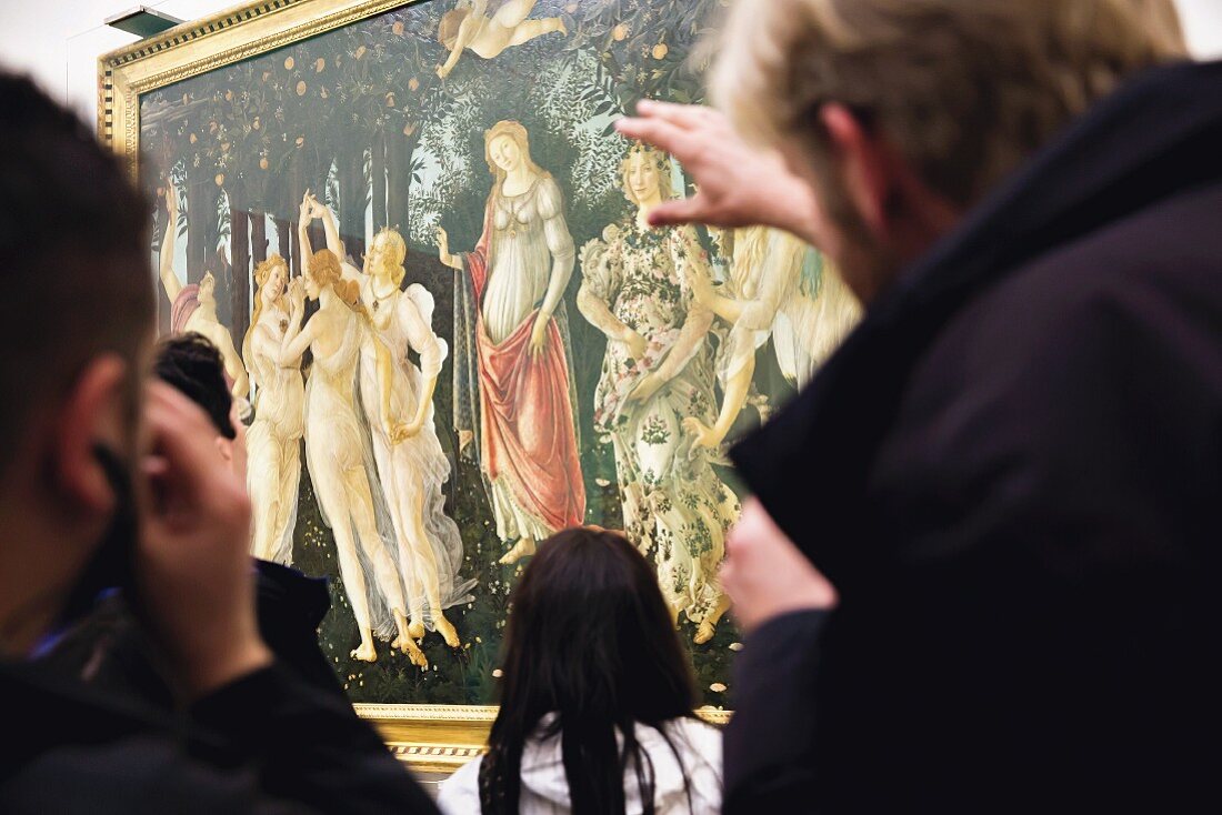 Touristen betrachten Botticellis 'Allegorie des Frühlings' hinter Glas in den Uffizien, Florenz, Italien