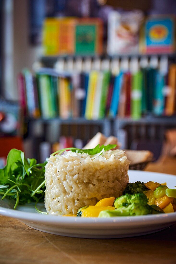 Risotto au Bouillon mit Gemüse- und Salatbeilage auf Tisch