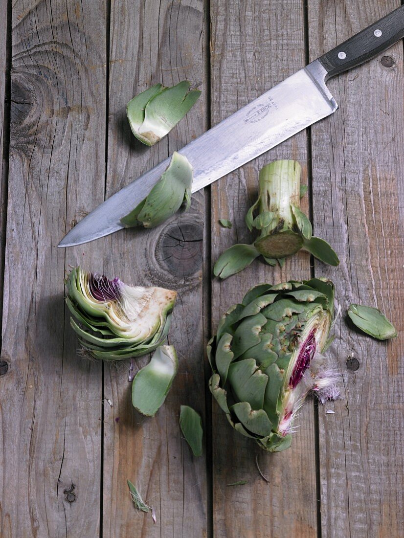 Chopped artichoke with a knife on a wooden background