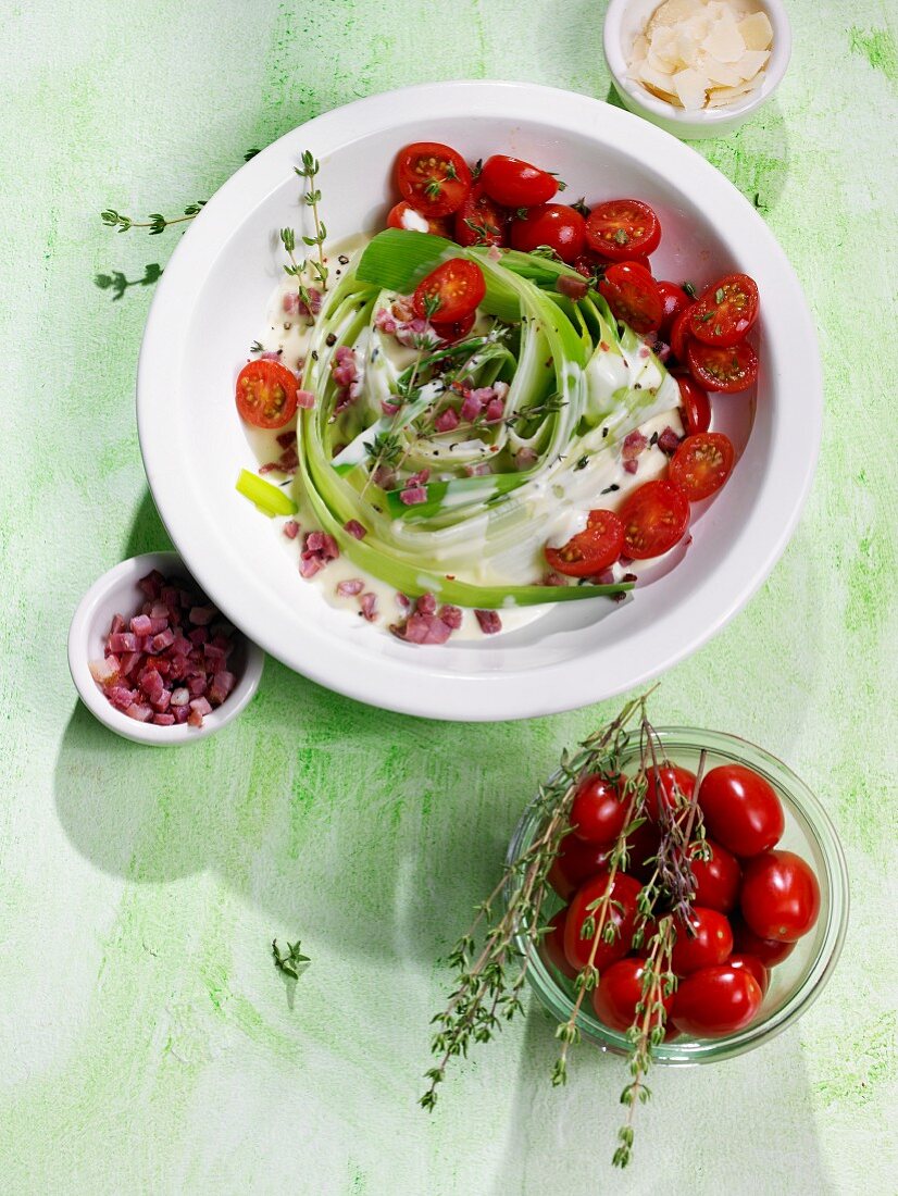 A leek nest with diced bacon, plum tomatoes and thyme