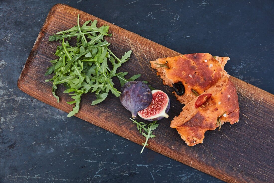 Rocket, figs and focaccia on a wooden board