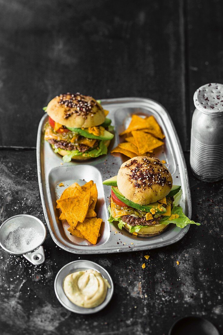 Burgers with beef, cheddar and lime mayo, avocado, and tortilla chips