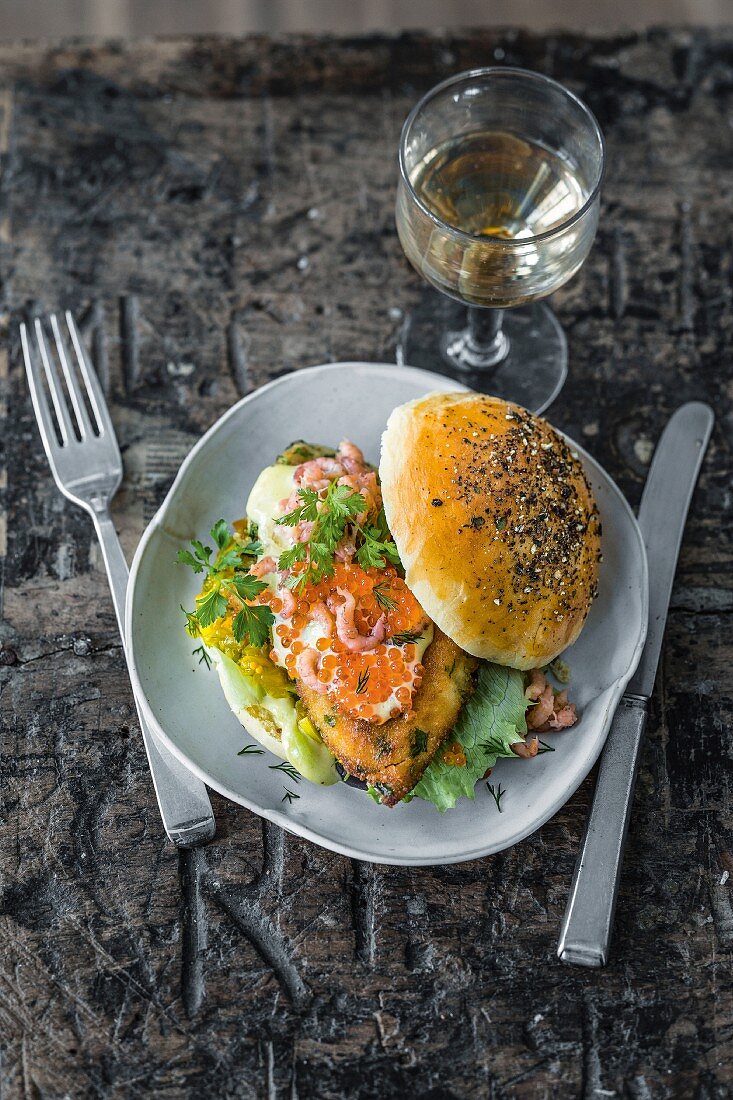 A fish burger with wasabi mayo, cucumber and apple relish, North Sea shrimp, and caviar