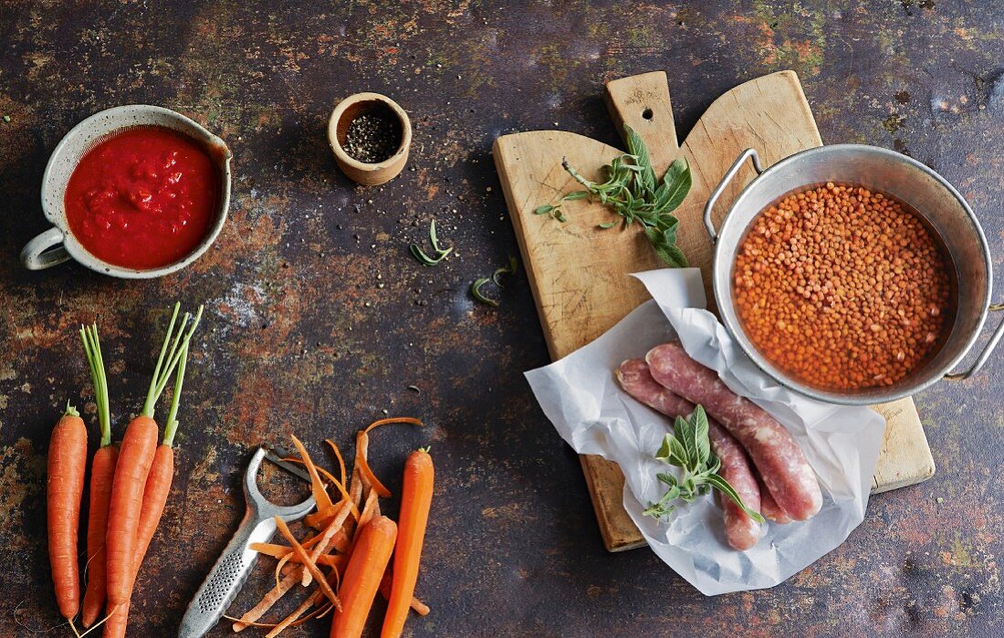 Ingredients for winter soups (carrots, tomatoes, lentils, salsicce)