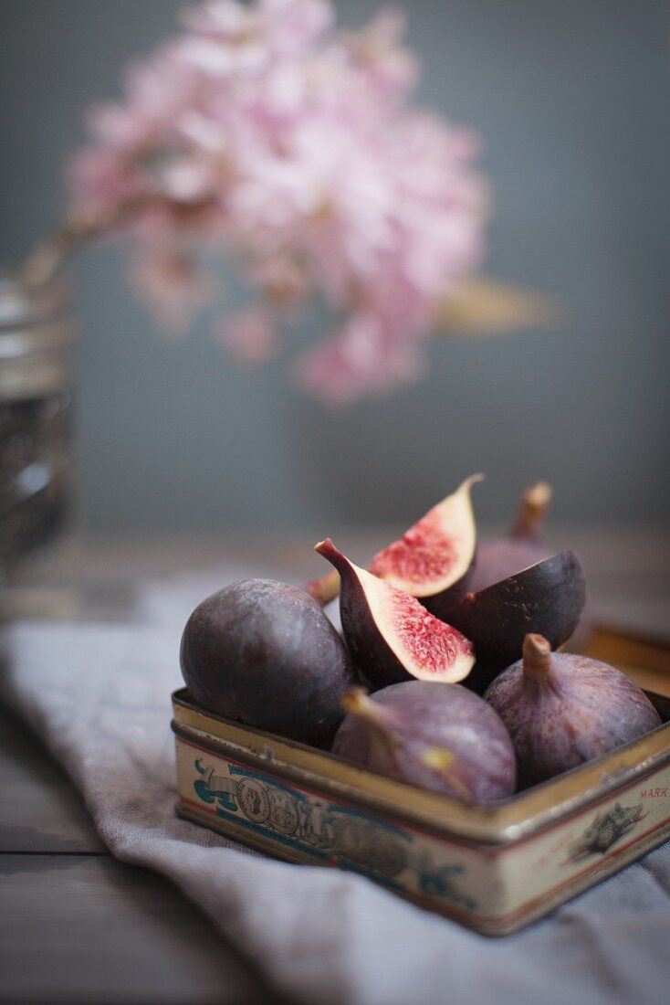 Vintage tin full of fresh figs topped with a quartered fruit
