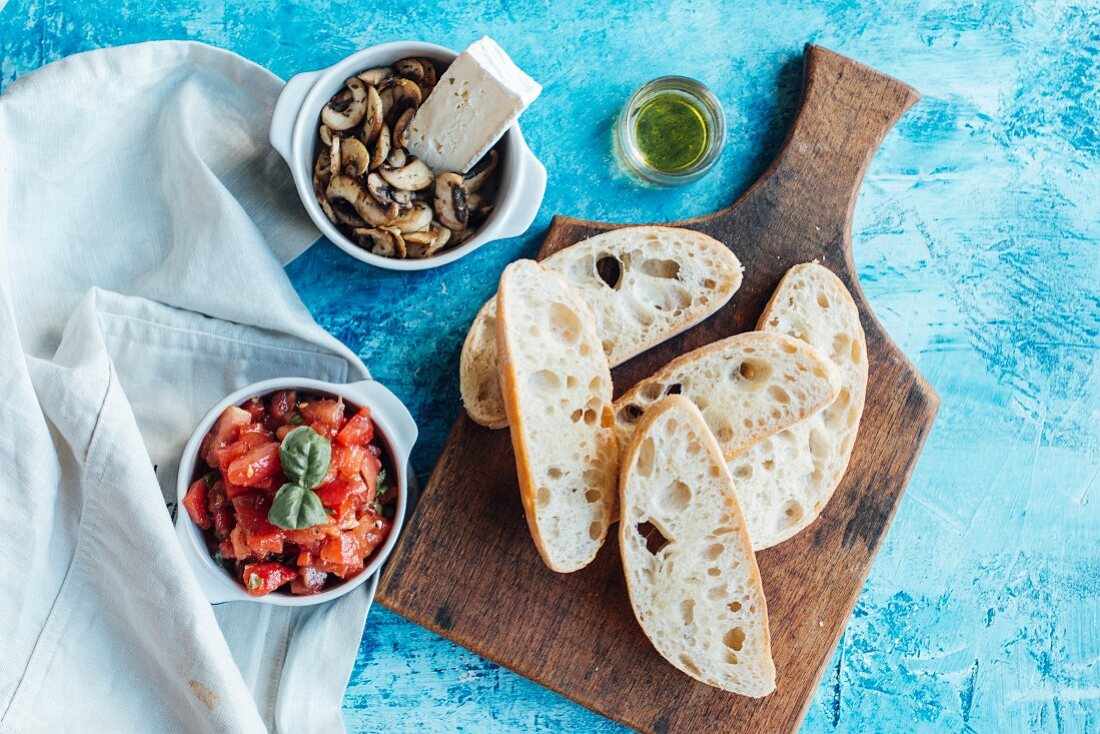 Ciabatta-Brotscheiben mit Toppings (Tomaten und Champignons mit Brie)