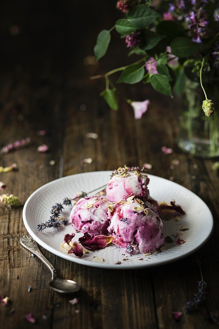 Blueberry ice cream with lavender and rose petals over wooden table