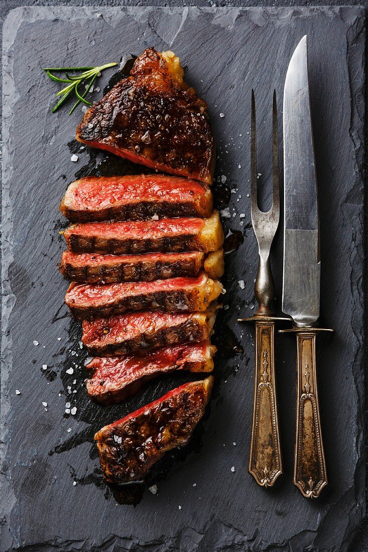 Medium gegrilltes Striploin-Steak, geschnitten auf Schieferplatte