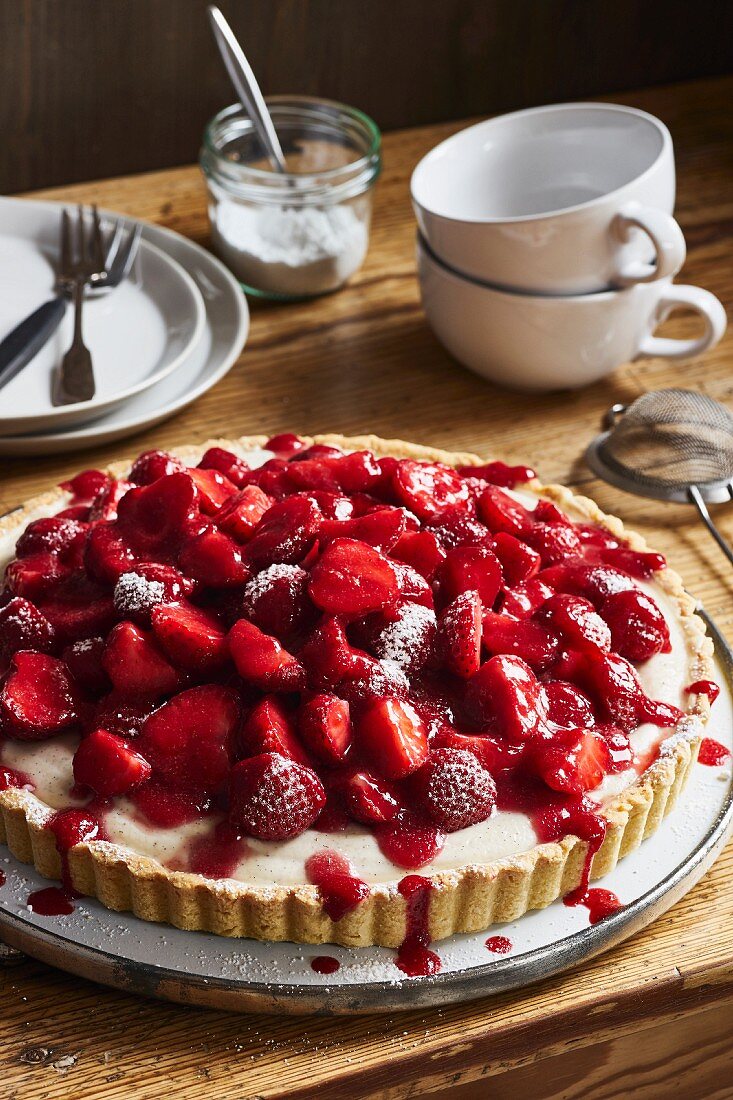 Erdbeertarte mit Vanillecreme auf rustikalem Holztisch