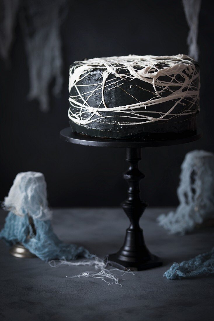 Halloween-Kuchen mit schwarzer Glasur und Marshmallow-Spinnennetz