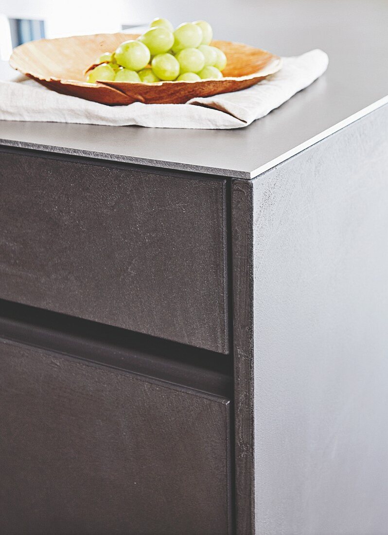 Küchenunterschrank mit Schubladenfronten in Betonoptik und Arbeitsplatte aus Stahl
