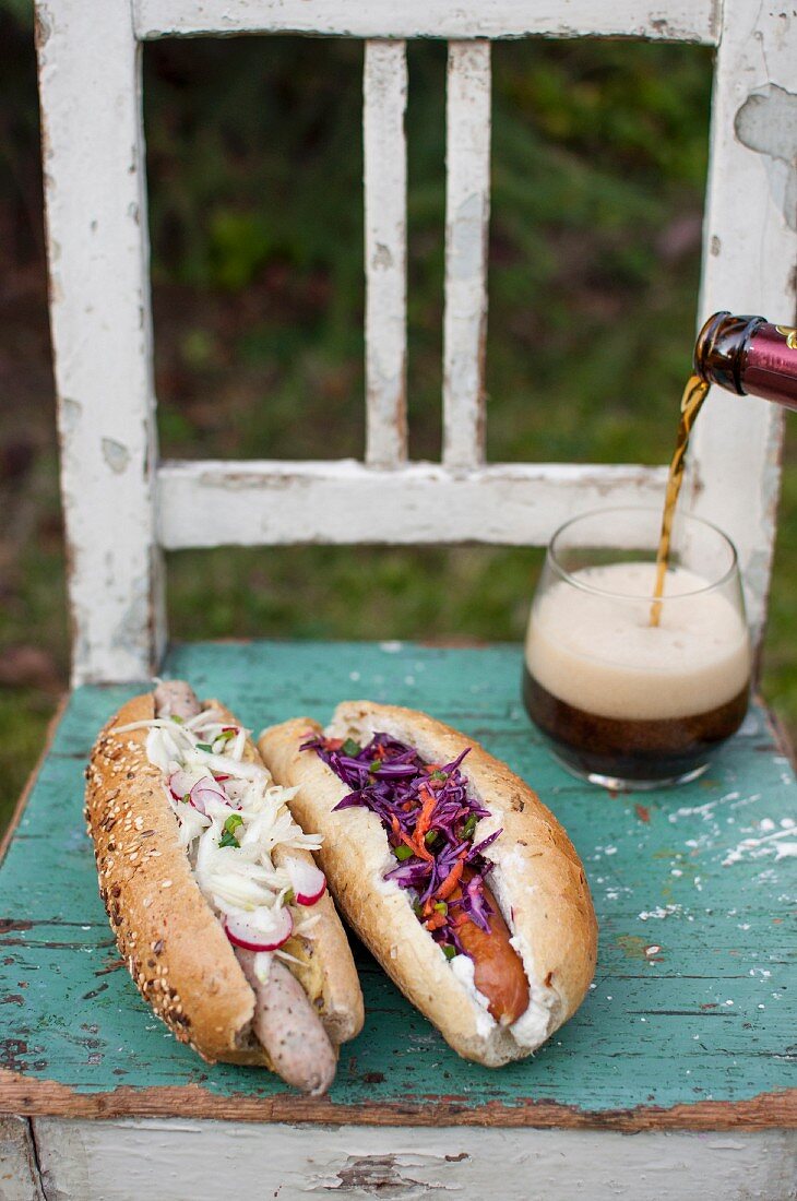 Hausgemachte Hot-Dogs mit verschiedenen Würsten, Krautsalat und Bier