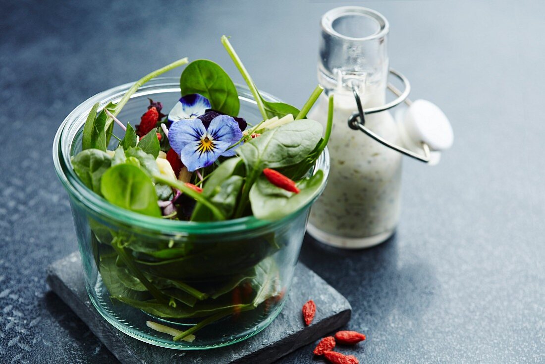 Spinach salad with goji berries, pansies, and a yogurt dressing