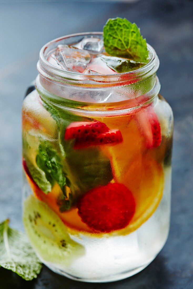 Water with fresh fruits, ice cubes and mint