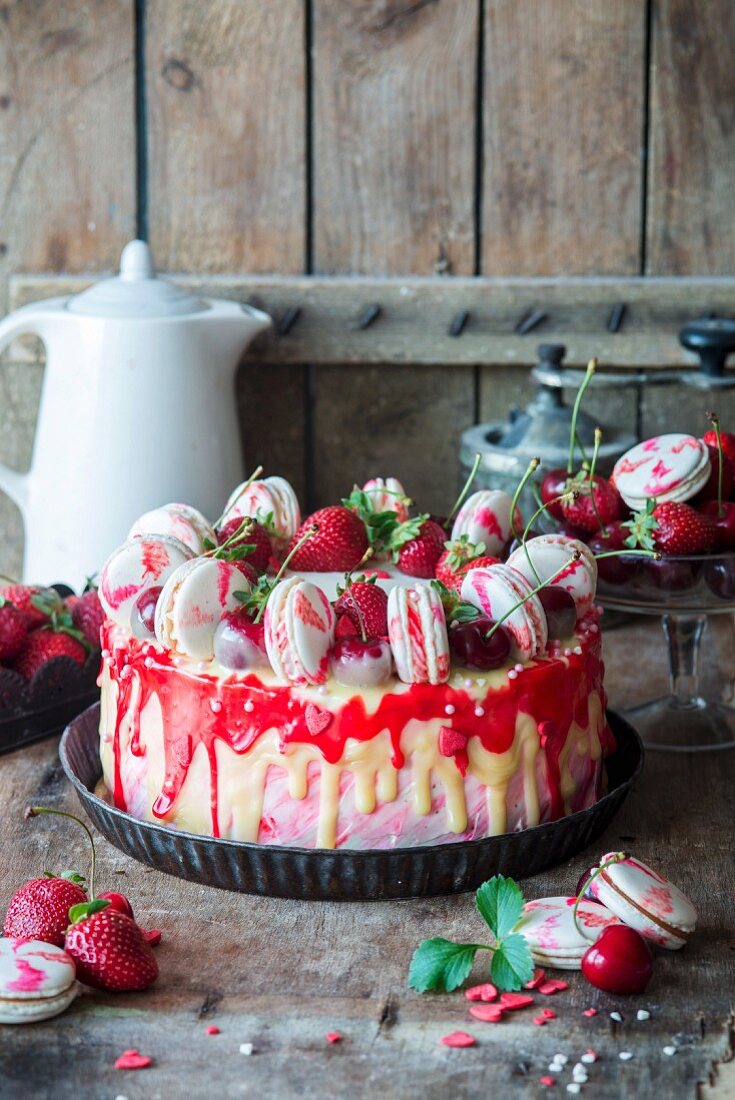 A strawberry and mascarpone torte decorated with white chocolate and macarons