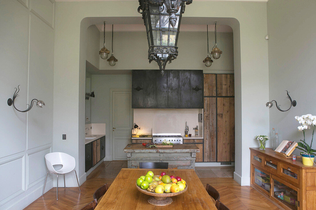 Dining room and open doorway leading into open-plan kitchen with wooden cupboards