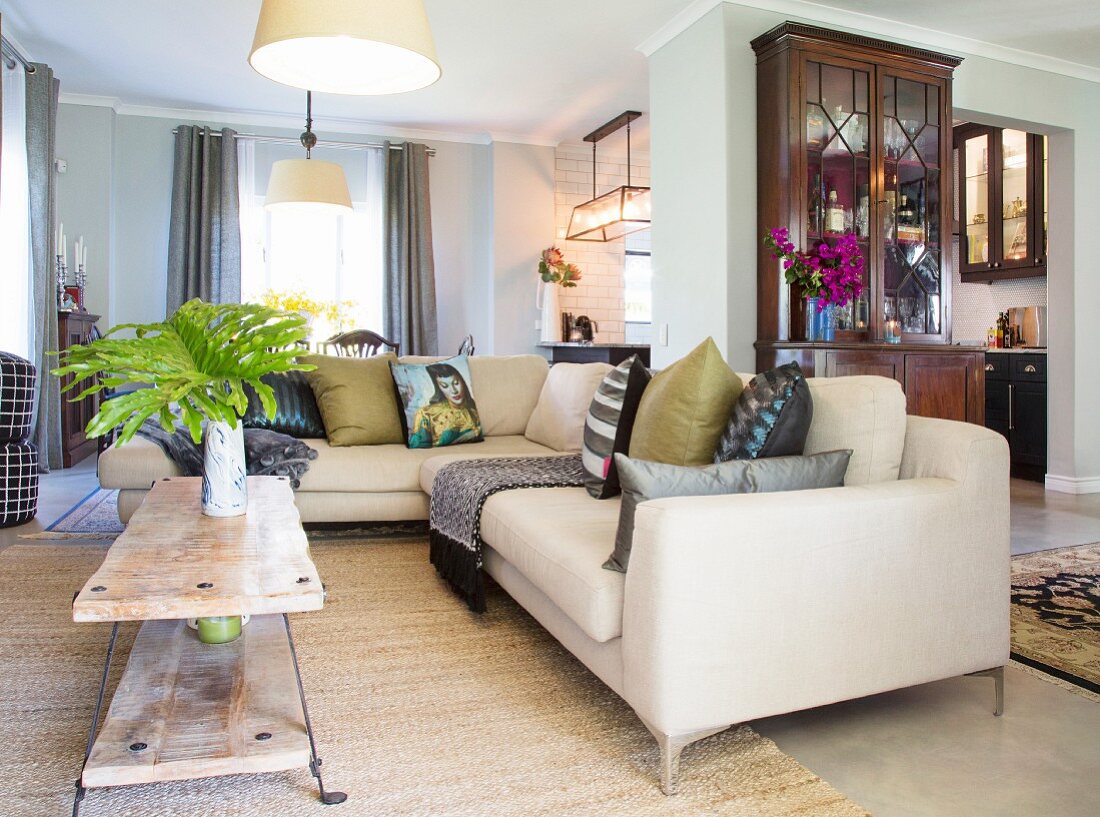 Pale corner couch and coffee table in open-plan interior