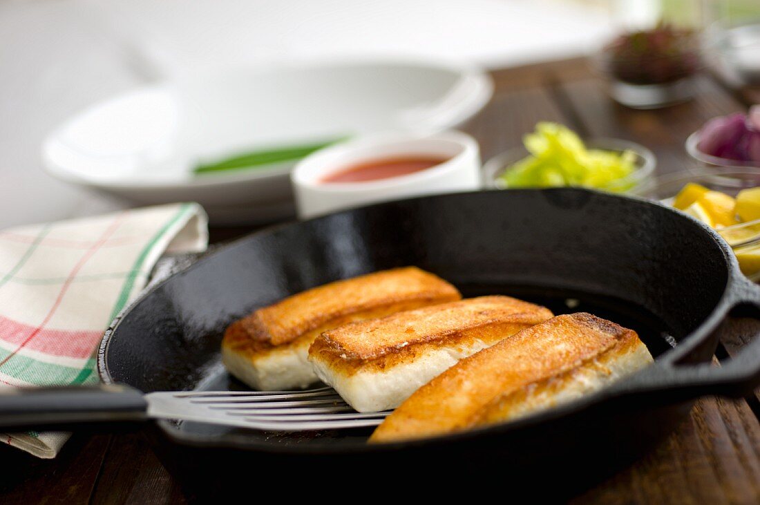 Fried halibut fillets in a pan