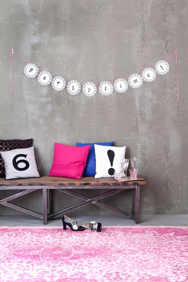 Letters written on garland of doilies decorating wall for party