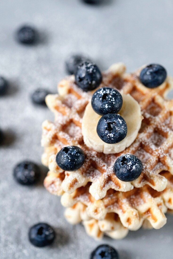 Waffles with banana and blueberry, dusted with powdered sugar