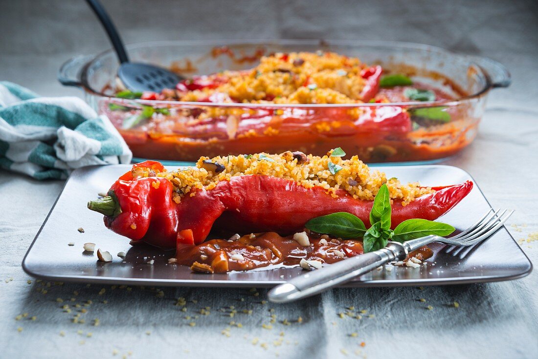 Mit Bulgur und Nüssen gefüllte Spitzpaprika in Tomatensoße (vegan)