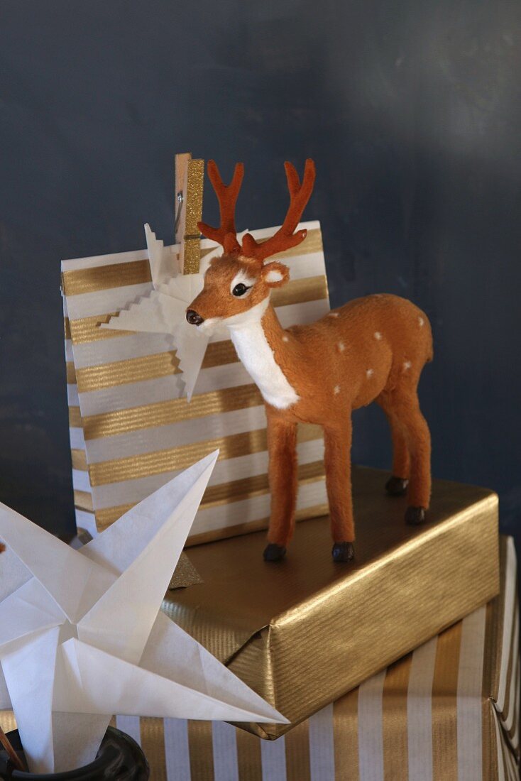 Christmas gifts wrapped in gold paper with stag figurine
