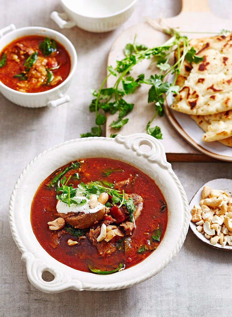Korma-Suppe mit Lammfleisch, Tomaten und Spinat serviert mit Naan-Brot (Asien)