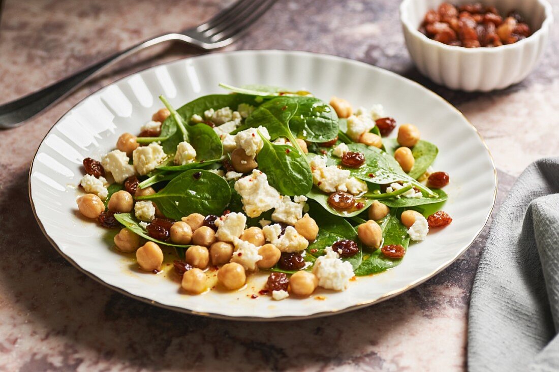 Oriental spinach salad with raisins, chickpeas and sheep's cheese