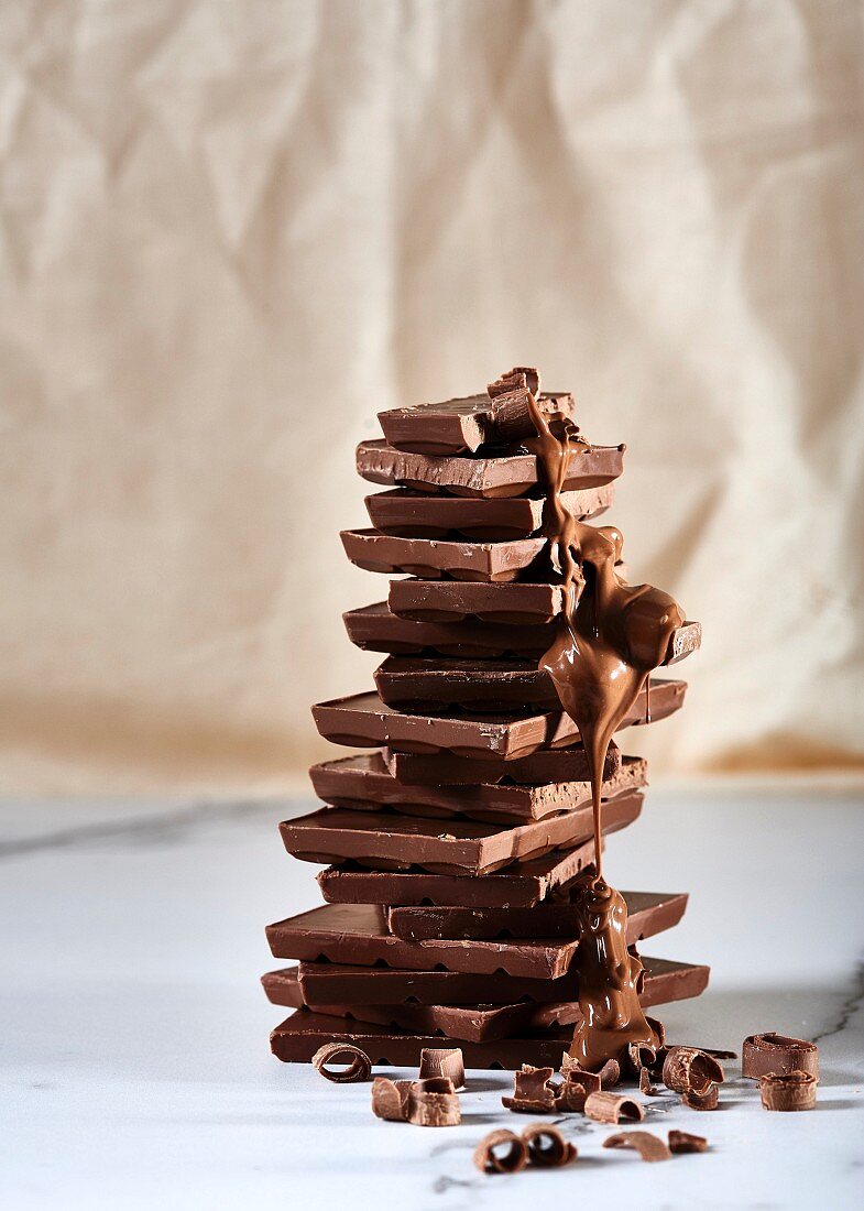 Stacked blocks of chocolate with chocolate sauce and chocolate curls