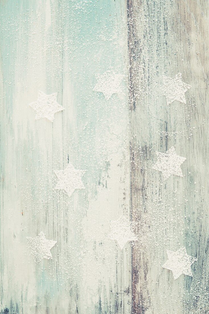 Powdered sugar stars on a wooden background with wood grain detailing