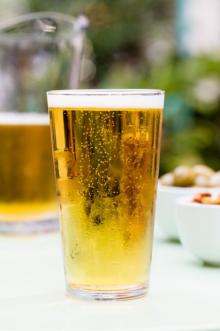 Helles Bier im Glas auf Gartentisch