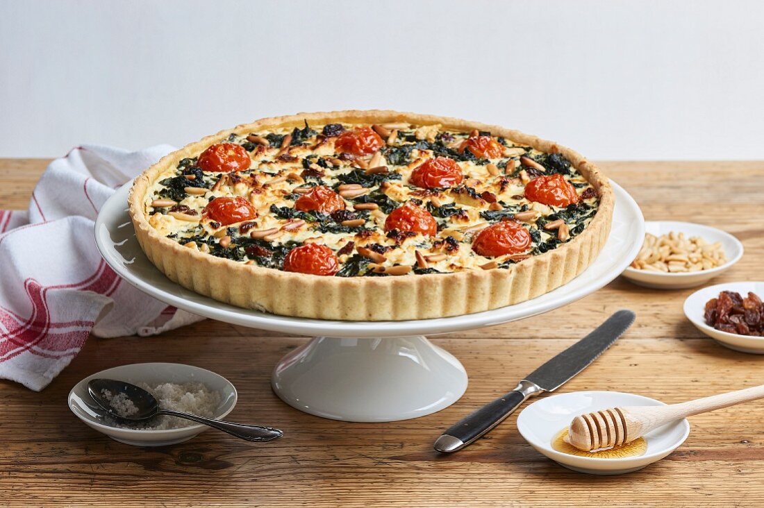 Spinach quiche with cherry tomatoes, raisins and pine nuts