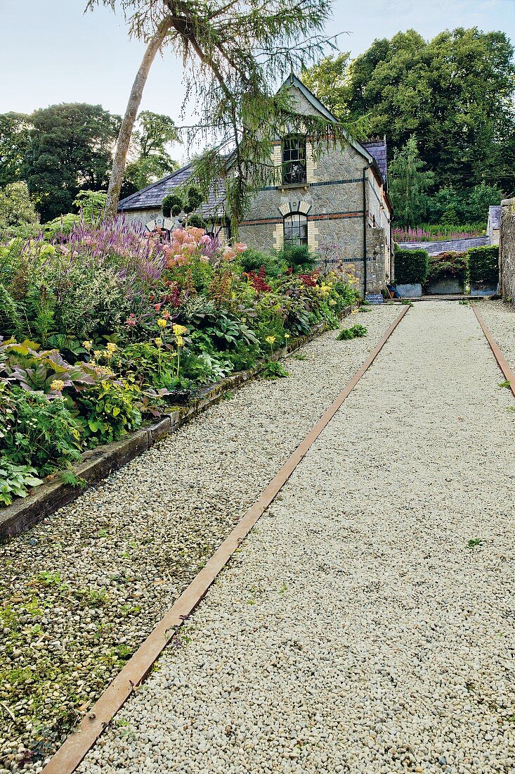 Kiesweg neben Blumenbeet führt zum Wohnhaus, Blessington, Irland