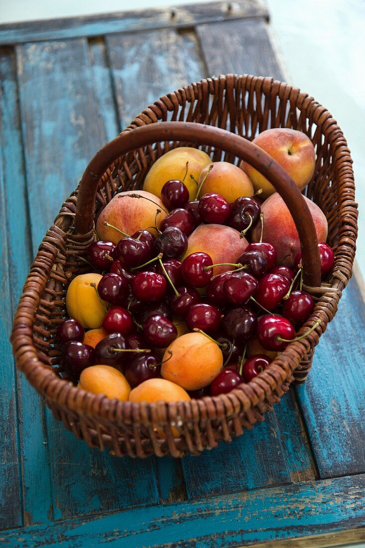 Fresh apricots, peaches and cherries in a basket
