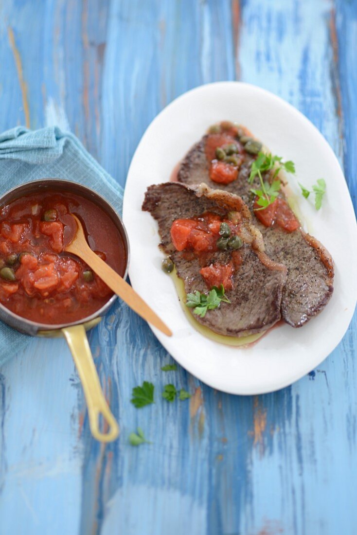 Beef slices with tomato and caper sauce
