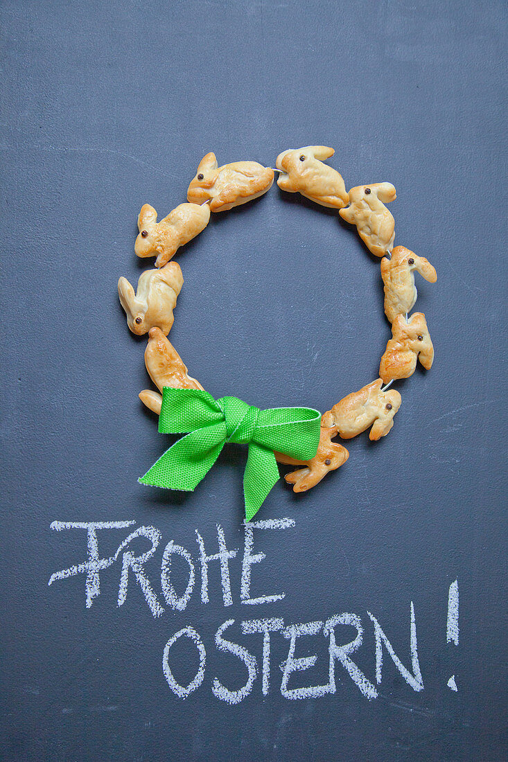 Wreath of pastry bunnies and Easter greeting on chalkboard