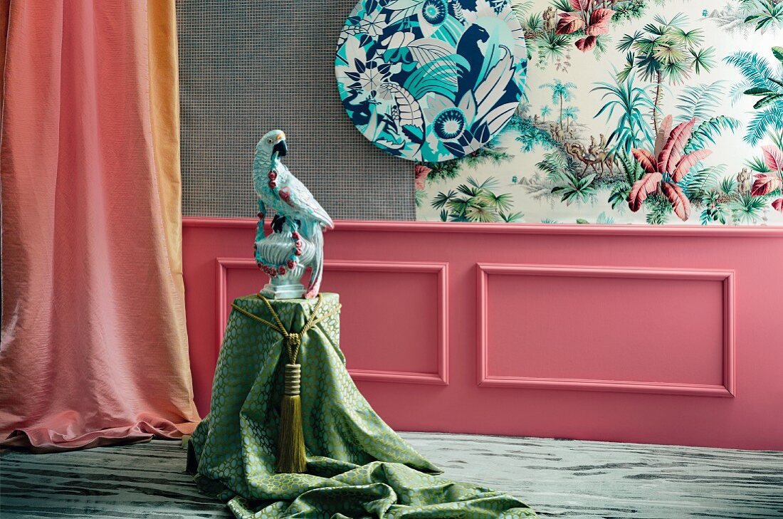 A fabric-covered wall panel with a decorative porcelain parrot in front of it