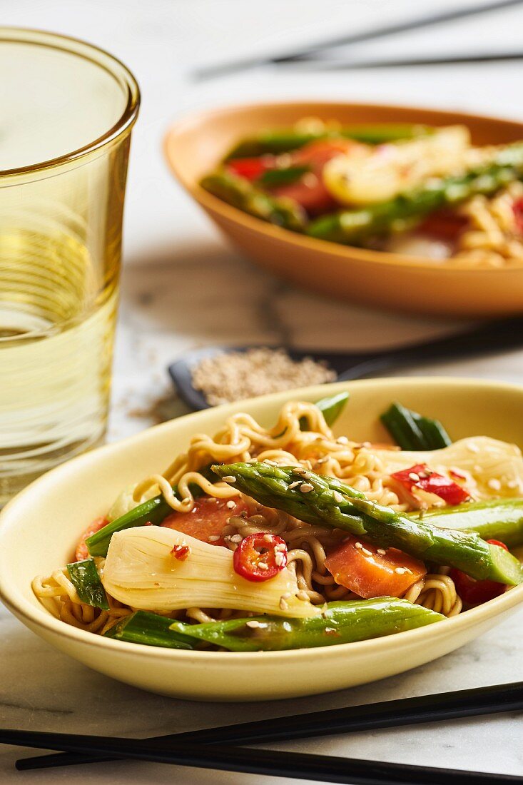 Asian noodles with green asparagus, spring onions, carrots, red peppers and sesame seeds