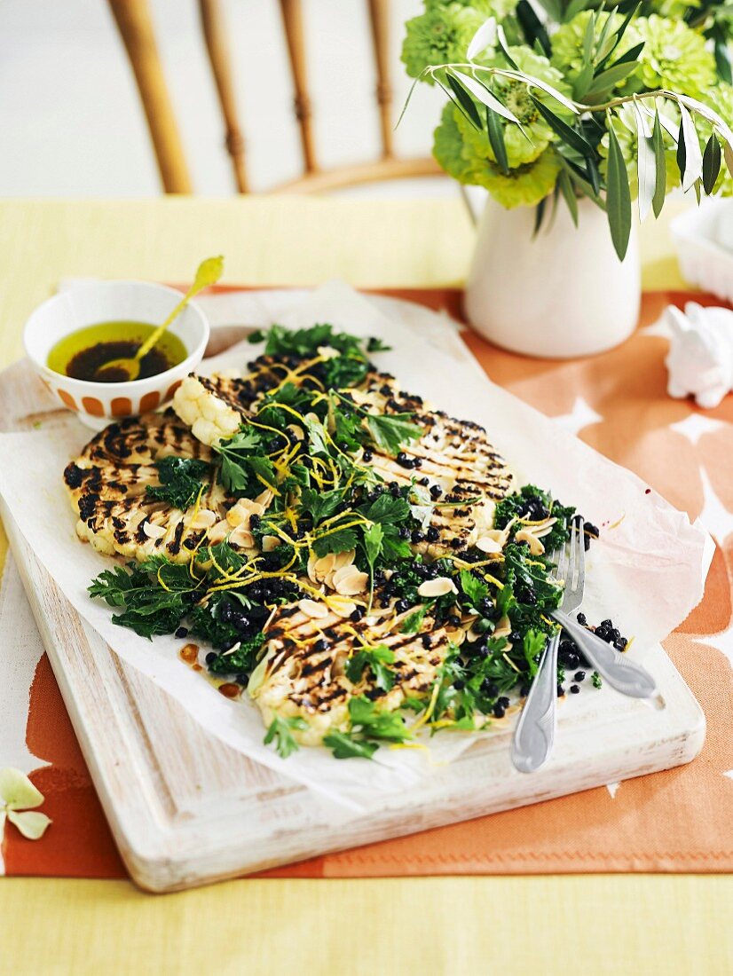 Grilled cauliflower with almonds, kale and currants