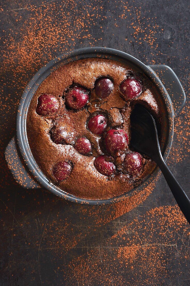Chocolate and cherry clafoutis, dusted with cocoa powder (top view)