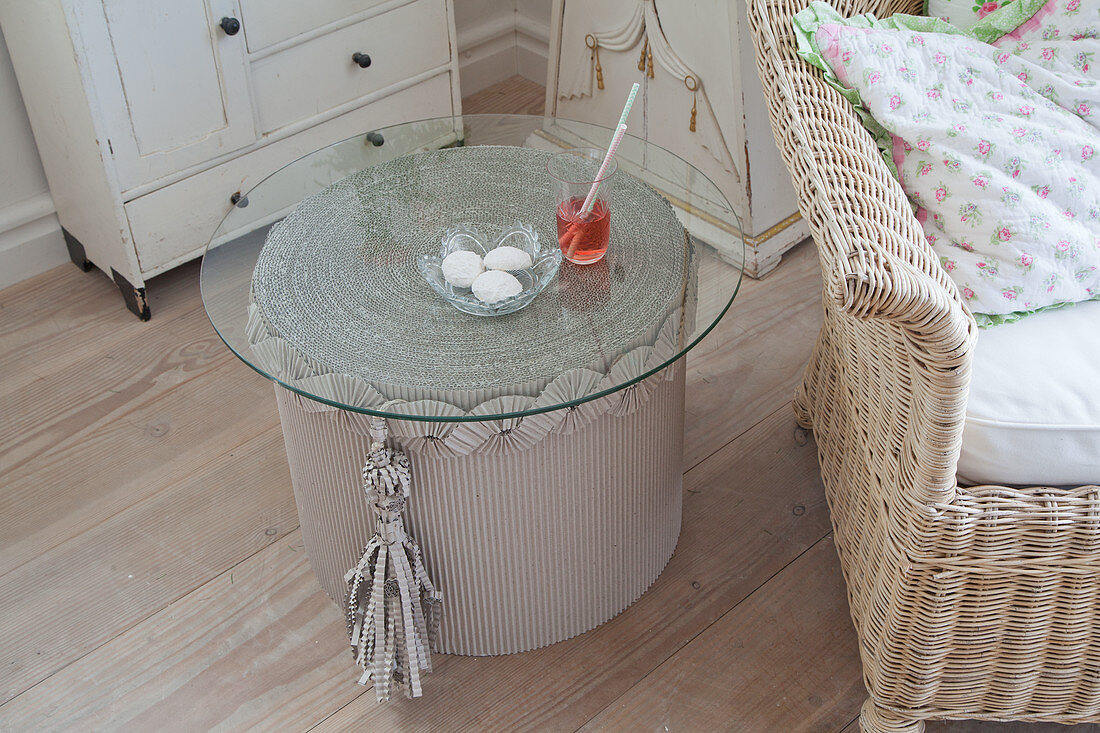 Side table made from corrugated cardboard with glass top in living room