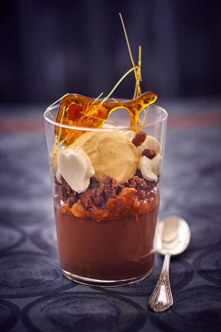 A chocolate and caramel dessert with vanilla ice cream in a glass