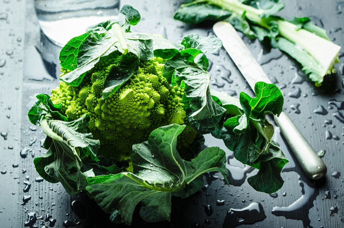 Romanesco mit Wassertropfen und Messer