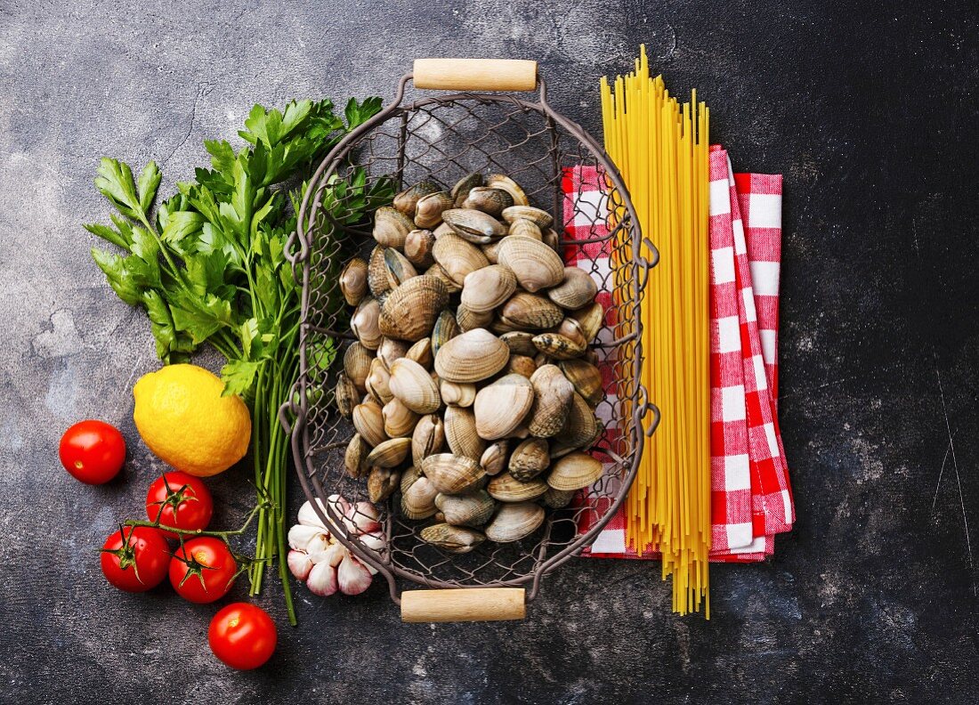 Raw food Ingredients for cooking Spaghetti alle vongole on dark background