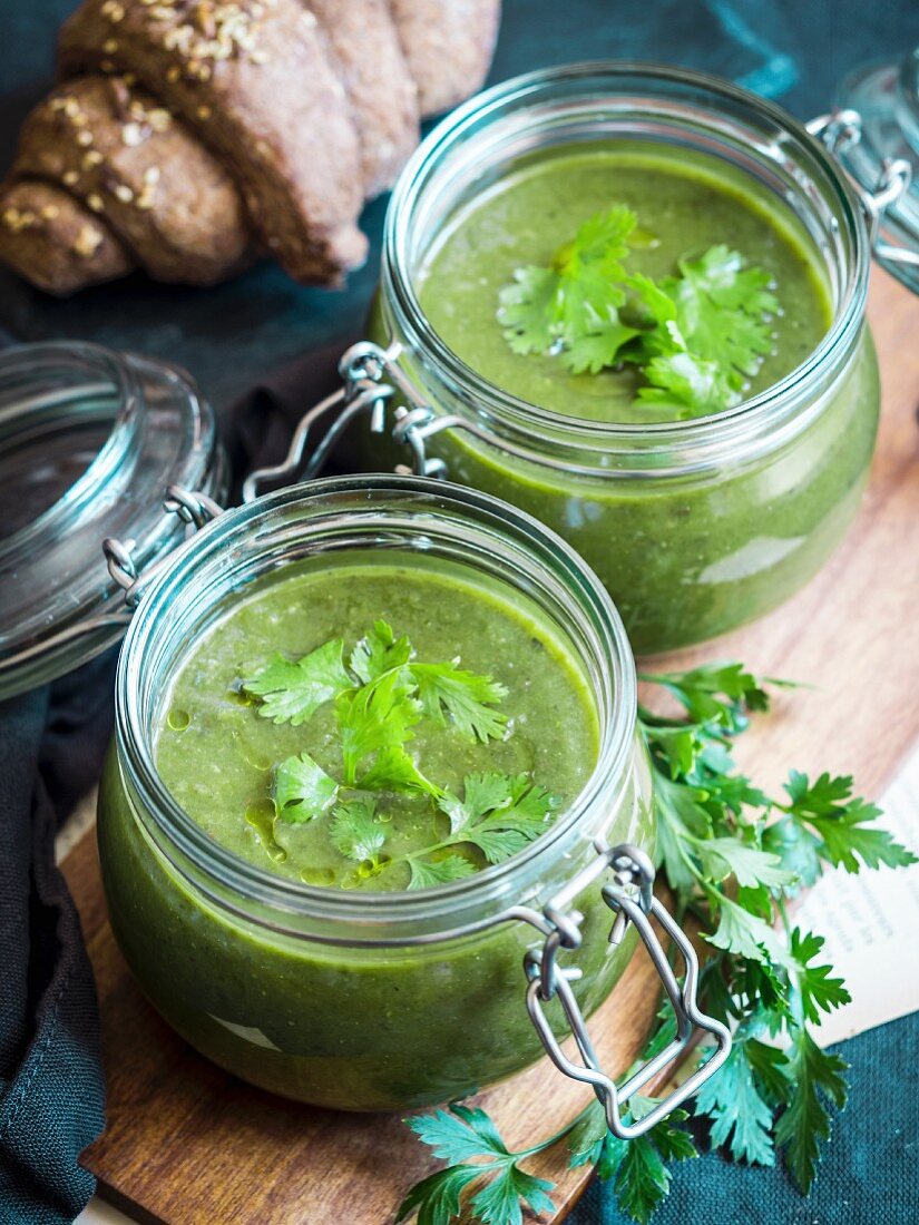 Cremige Suppe aus gebackener Zucchini, Süßkartoffel und Spinat, serviert in Gläsern