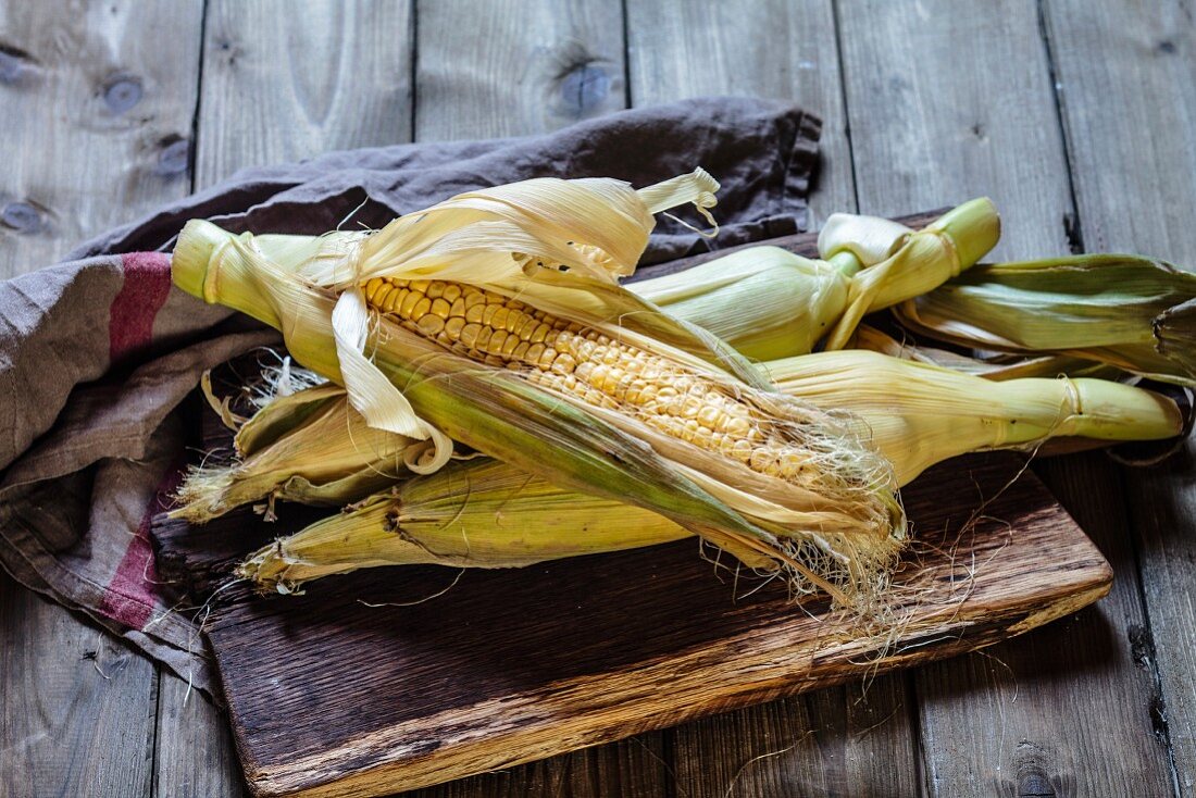 A corn cob on a wooden board