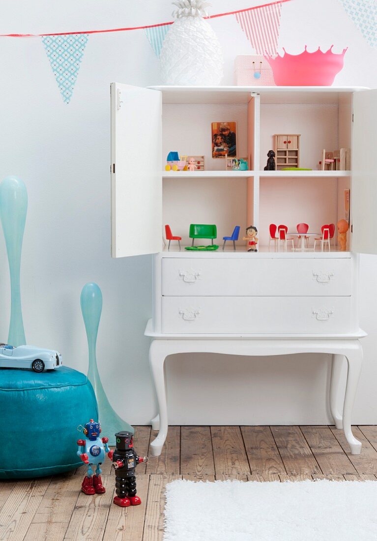 White-painted antique cabinet converted into dolls' house in retro girl's bedroom