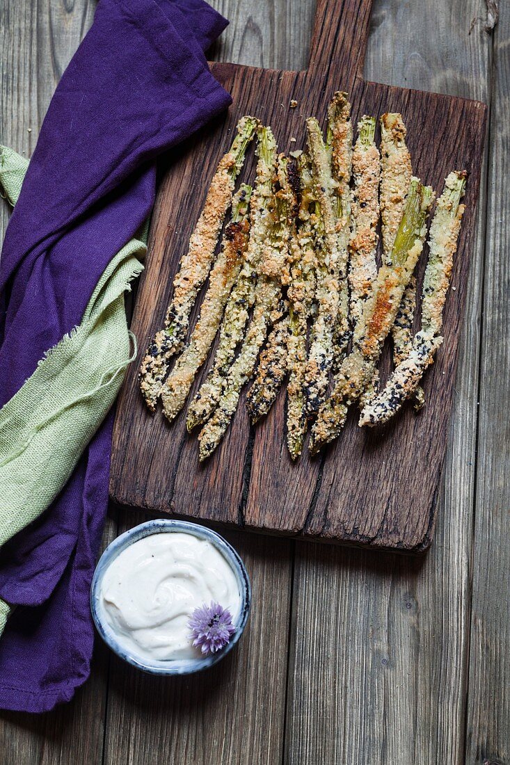 Fried breaded asparagus with almond flour and sesame seeds, and a herb dip