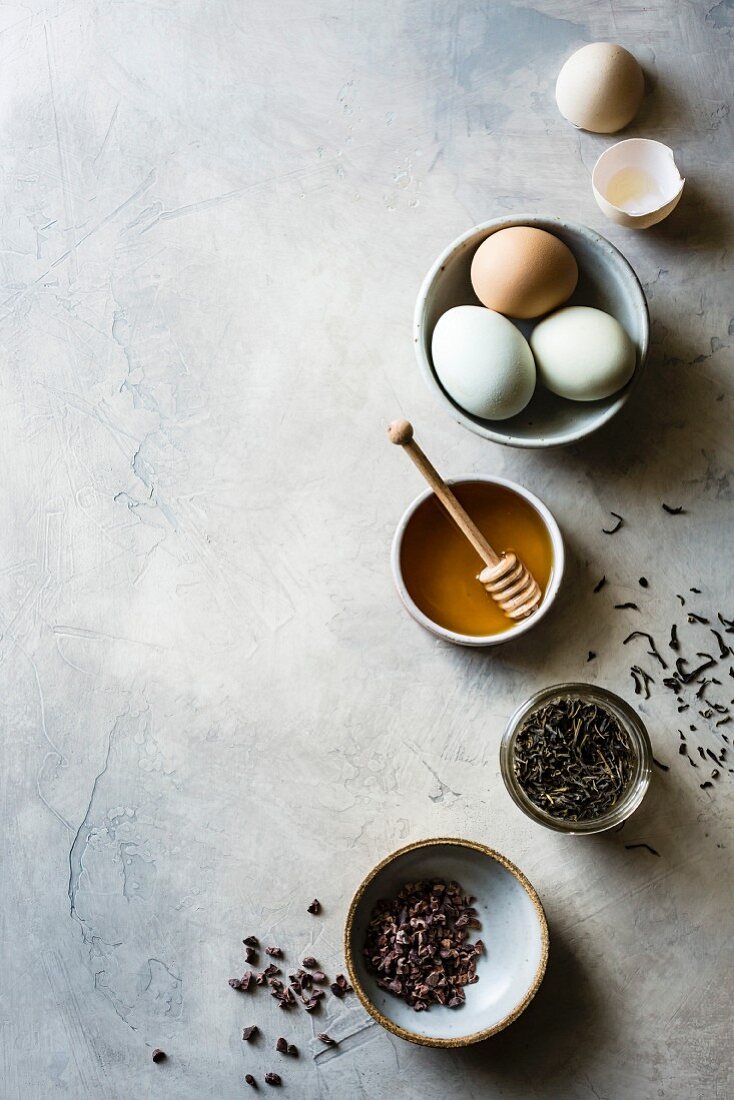 Honey, eggs, tea, cacao nibs on a light background